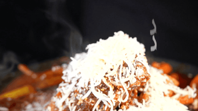 Cheese powder falling onto spicy braised short ribs