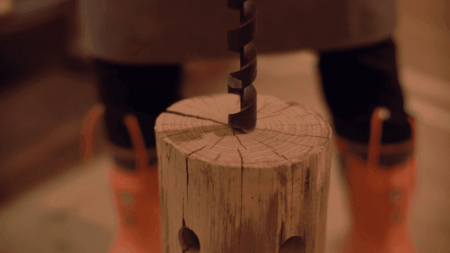 실내에서 나무 통에 드릴 작업