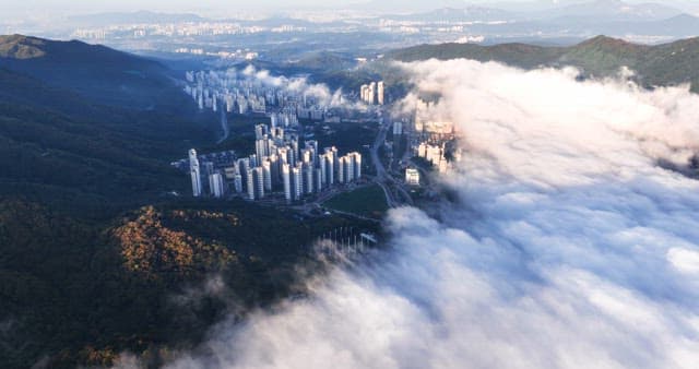 산 위로 구름이 덮인 도시 전경