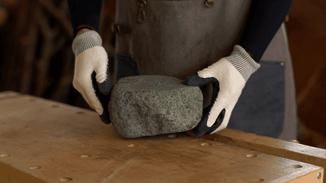 나무 테이블 위의 돌을 살펴보는 사람