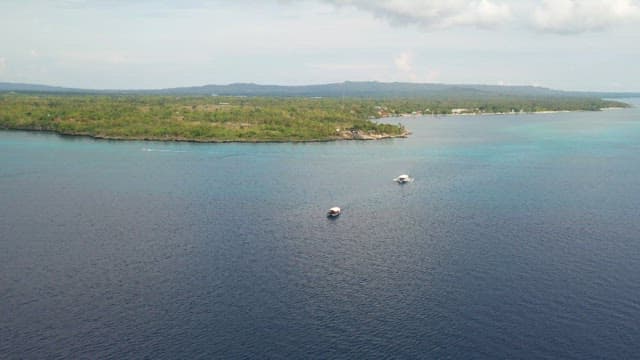 Boats sailing near the tropical island coast