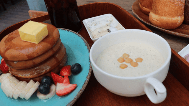 과일과 함께 제공되는 버터와 시럽을 얹은 팬케이크