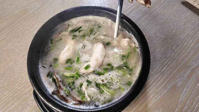 Chicken soup stirred with spoon