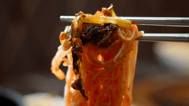 Spicy bibim noodles picked up with chopsticks