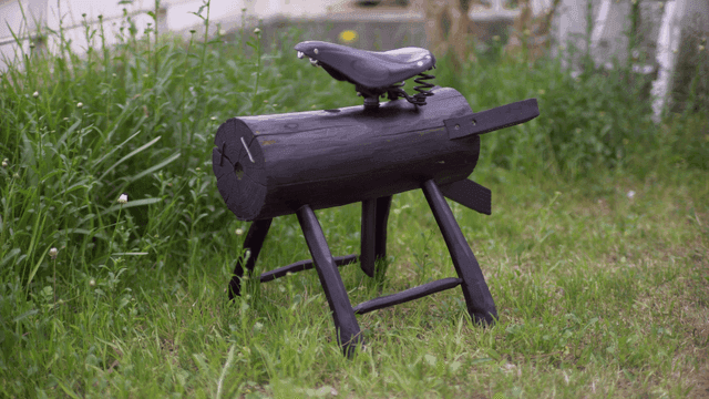 잔디밭에 자전거 안장이 있는 나무 조각상