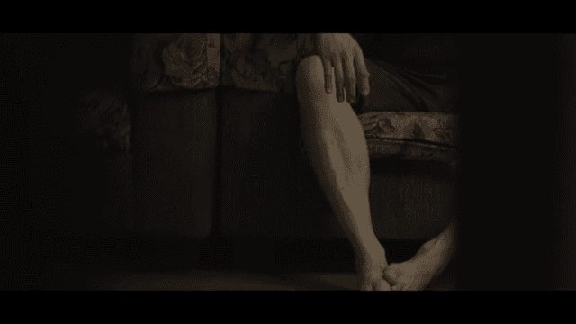 Person sitting on a couch with broken glass