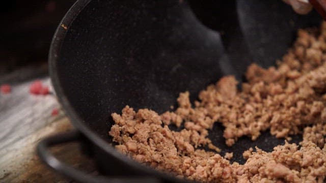 팬에서 나무 주걱으로 조리되는 다진 고기