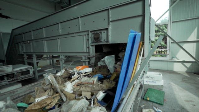 Conveyor belt transporting various waste materials indoors