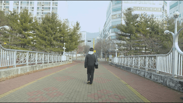 Back view of man walking on city bridge