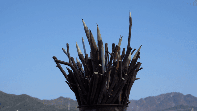 맑은 하늘 배경의 나뭇가지 연필 조각품