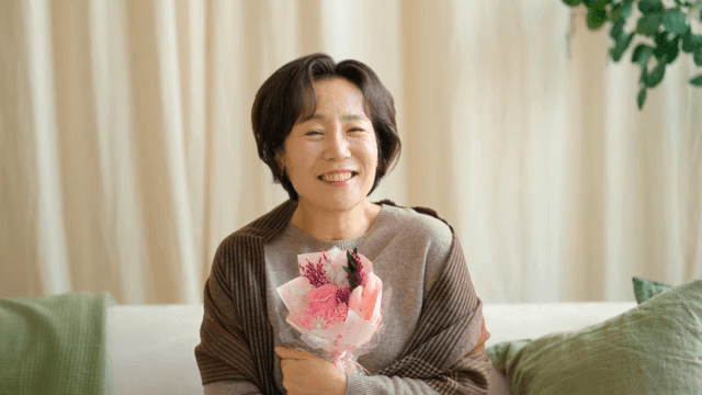 Woman joyfully holding a bouquet indoors