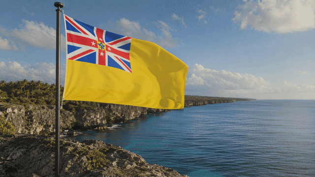 Niue flag fluttering atop coastal cliffs