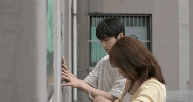 Two people posting poster on wall