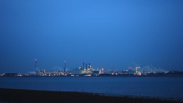 산업 도시가 보이는 황혼의 바닷가