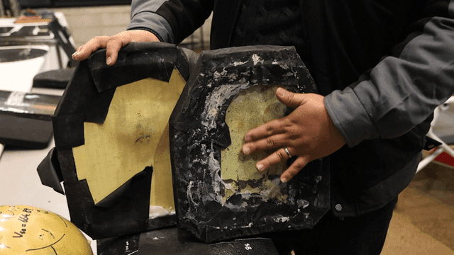 Person inspecting damaged protective equipment