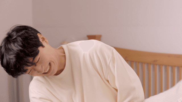 Young man laughing during playful pillow fight