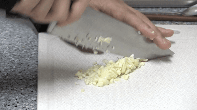 도마 위에서 마늘을 다지는 모습