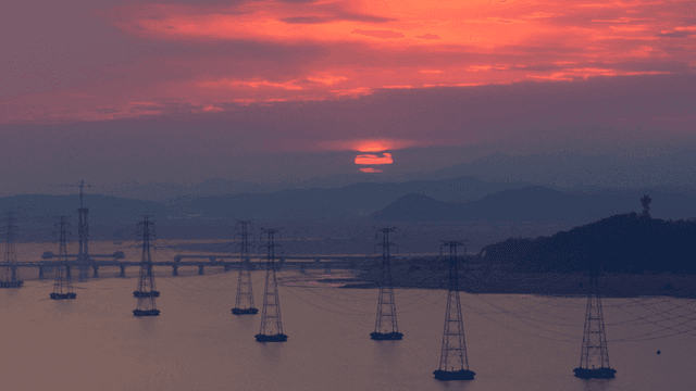 멀리 언덕이 보이는 강 위의 일몰