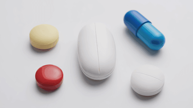 Various pills and capsules on a white surface