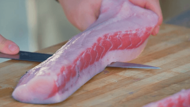 Preparing fish on a wooden cutting board