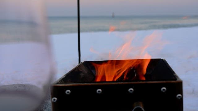 Cozy campfire on a snowy beach at dusk