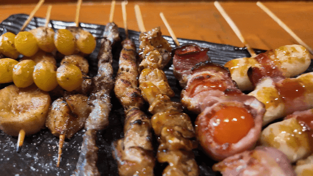 Assorted skewers on black plate