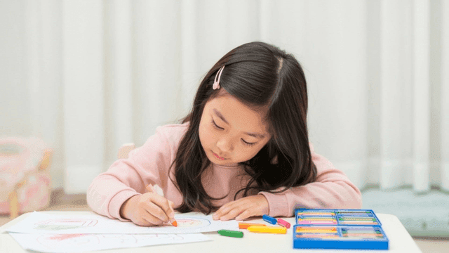 크레용으로 그림 그리는 어린 소녀