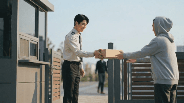 Security guard handing package to resident