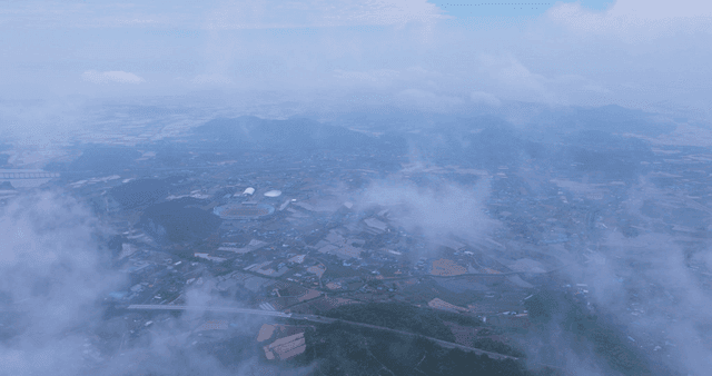 Rural village with rice paddies under cloudy sky