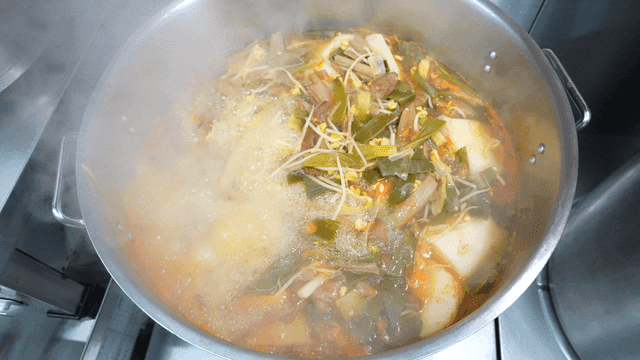 Beef stew boiling in large pot