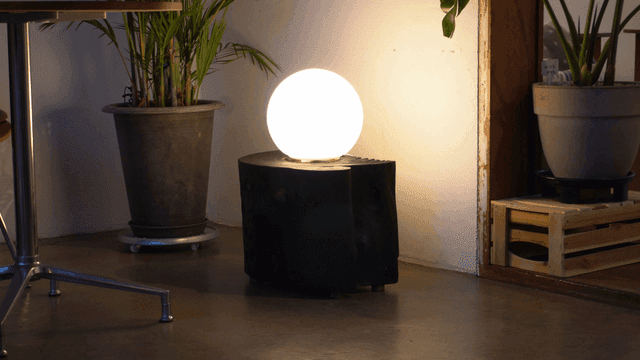 화분들과 둥근 램프가 있는 아늑한 실내 공간