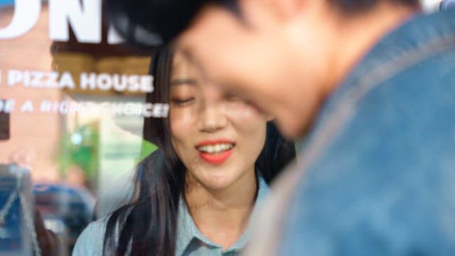 Couple playing around through a glass door