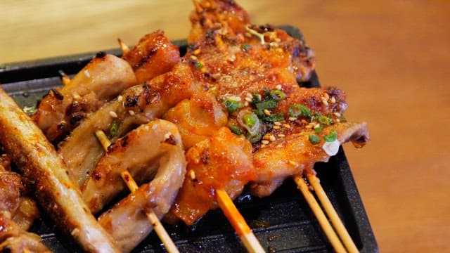 Various types of grilled skewers neatly arranged on an iron plate