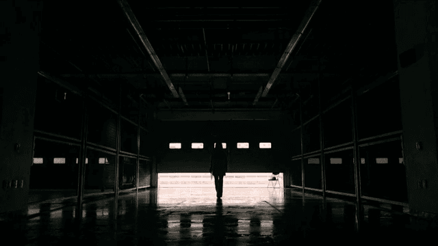 어두운 차고에서 나가는 사람