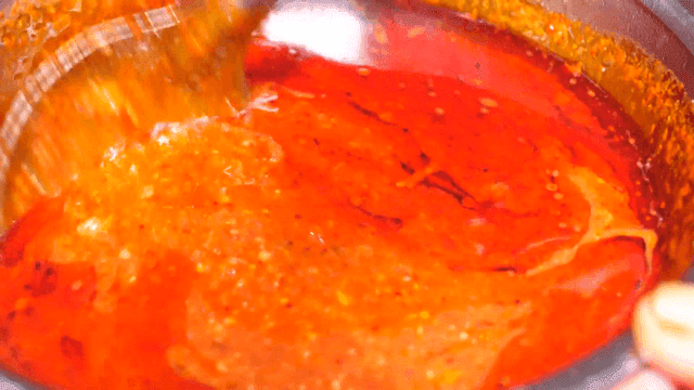 한국식 매운 양념을 저어 섞는 장면