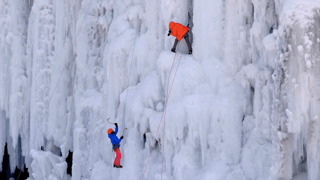 얼어붙은 폭포를 오르는 아이스 클라이머