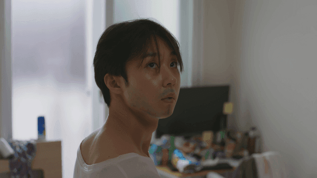 방 안에서 주변을 둘러보는 남자