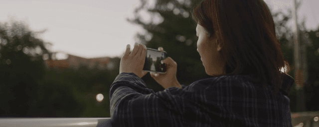 다리 위에서 풍경을 찍는 여성