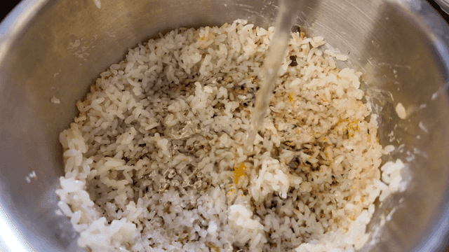 Water poured over scorched rice in pot