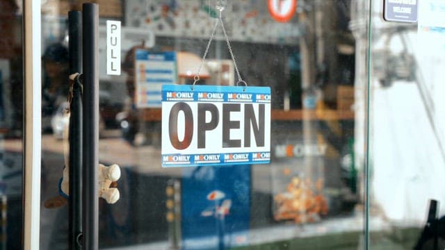 피자 가게 표지판을 돌려 닫힘을 알리는 여성