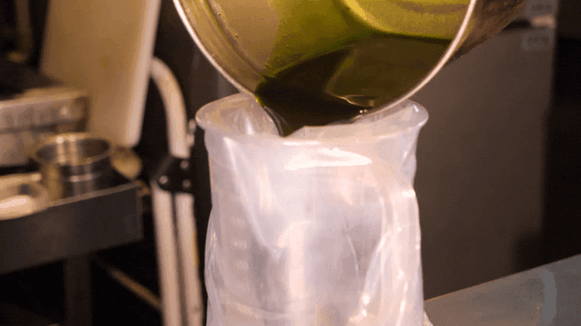 Pouring green liquid into a container