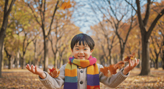 Boy playing with autumn leaves in a park