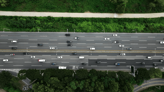 Busy highway surrounded by greenery.