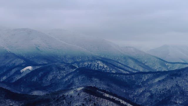 Snow-covered mountains under cloudy skies