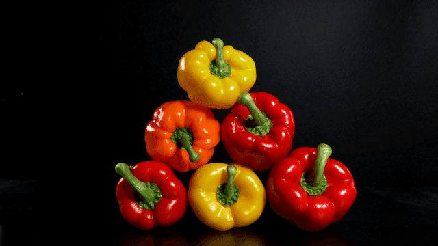 Colorful bell peppers stacked on a table