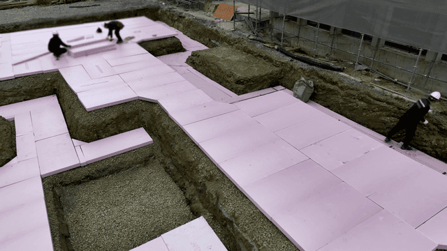 건설 현장에서 단열재를 깔고 있는 작업자들