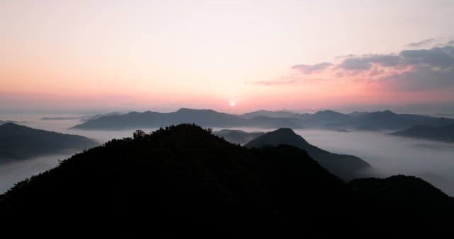 Sky Colored by Sunrise over Foggy Mountains