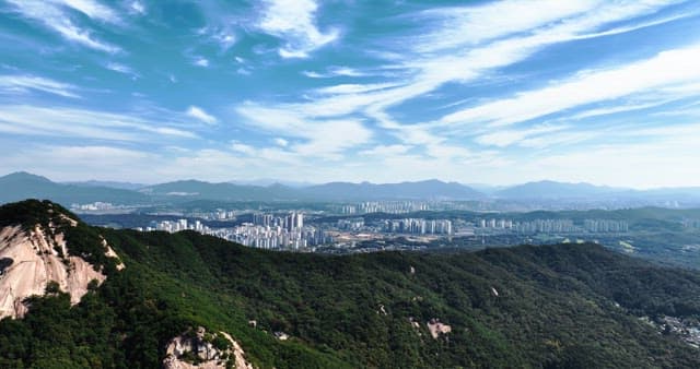 산과 맑은 하늘이 보이는 도시 풍경