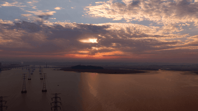 바다 위로 지는 해와 송전선