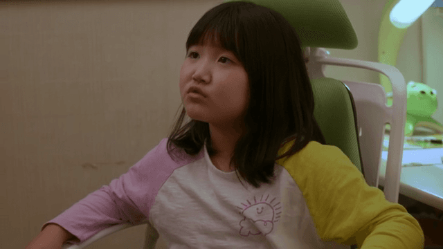 책상에 앉아 누군가와 대화하는 아이